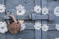 The old metal wrought-iron door is locked with a padlock. Closed metal lock. Royalty Free Stock Photo