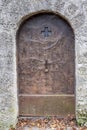 An old metal wrought-iron door, a wall of stones, the entrance to the dungeon of an ancient castle. Royalty Free Stock Photo