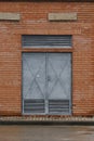 Old metallic grey door with attention high voltage sign