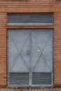 Old metallic grey door with attention high voltage sign
