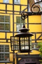 An old metallic lantern hanging from a yellow brick wall in Copenhagen, Denmark Royalty Free Stock Photo