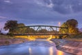 Old, metallic railroad bridge over silky water during blue hour Royalty Free Stock Photo