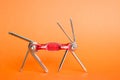 Old metallic red bike multi-tool is going to fix, repair and service on an orange background. Bicycle multifunction hand tool. Royalty Free Stock Photo