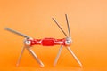 Old metallic red bike multi-tool is going to fix, repair and service on an orange background. Bicycle multifunction hand tool. Royalty Free Stock Photo