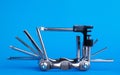Old metallic unfold bike multi tool set with chain remover on a blue background. Bicycle multifunction tool. Royalty Free Stock Photo