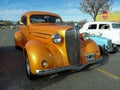 old metallic yellow 1936 Chevrolet Master coupe street rod in a parking lot. Classic car show. Royalty Free Stock Photo