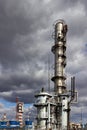 Old methanol distillation rectification refinery column towers and reactors under stormy sky with dark clouds background