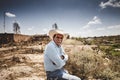 Old Mexican Cowboy sitting with denim shirt in the desert