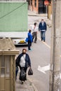 Old & middle aged women & men wearing masks; walking on the streets of Bogota, Colombia. Carrying black plastic bags.