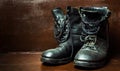 Old military boots against wooden background Royalty Free Stock Photo