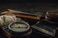 Old military compass, rusty hunting bushcraft knife, small axe and a linen rope on the dark wooden table. Royalty Free Stock Photo