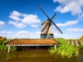 An old mill in the Netherlands. Historical building. A mill near a canal. Dutch architecture and history.