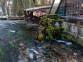 An old mill wheel covered with moss on the Plava Voda stream in Travnik in the autumn during the evening