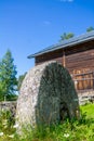 Old millstone in front of barn