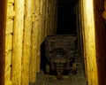 Old mine cart in lighted tunnel at entrance of ore mine Royalty Free Stock Photo