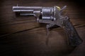 Old mini revolver on wood background