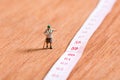 Old miniature traveler with 60th number of age on measuring tape Royalty Free Stock Photo