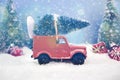 Old miniature truck or oldimer with a christmas tree on the roof driving trough a winterly landscape with some kind of christmas d Royalty Free Stock Photo