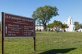 Old Mission San Luis Rey entrance sign with mission building in rear