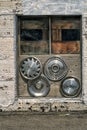 Old mixed hubcaps in a window