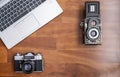 An old 35mm reflex camera and an old medium format twin lens reflex camera seen from above with a modern laptop next to them