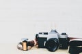 Old 35mm SLR film camera and a roll of film on wooden background. Flim photography concept Royalty Free Stock Photo