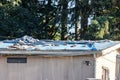 old mobile manufactured home with trash and rocks on roof