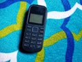 Old Mobile Phone with Texting or SMS Button Keyboard or Keypad on Colorful Carpet Background Royalty Free Stock Photo