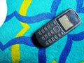 Old Mobile Phone with Texting or SMS Button Keyboard or Keypad on Colorful Carpet Background Royalty Free Stock Photo