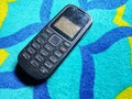 Old Mobile Phone with Texting or SMS Button Keyboard or Keypad on Colorful Carpet Background