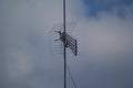 old model television antenna or analog TV antenna, photographed from below with a cloudy sky as a background