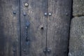 Old and modern lock on old dark door with iron handle in horizontal