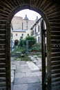 Monastery Yard with Bushes through Age-old Wooden Door Royalty Free Stock Photo