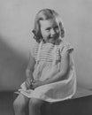 Old monochrome studio photograph of a pretty Caucasian young girl wearing ringlets dating to the 1930s, Edwardian era.