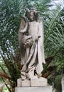 Old monument, angel with flowers. The child looks at the flower.