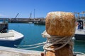 Old Mooring Bollard with rope Tied on Pier. Boat Tied With a Rope on a Mooring Royalty Free Stock Photo