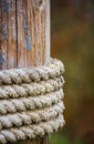 Old mooring rope wrapped on a wooden pole while holding the moored vessel Royalty Free Stock Photo