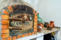 Old Moorish oven with rusty metal door with accessories and ceramic tableware