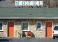 Old motel with two red doors and chairs out front Royalty Free Stock Photo