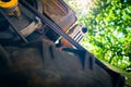 Old motoblock for agriculture, foreshortened view from below against the background of green foliage on a blurred background Royalty Free Stock Photo