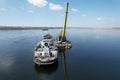 An old motor ship is anchored under sand loading