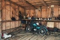 Old Motorbike In A Picturesque Barn. Vintage Motorcycle In Old Hangar With Many Rare Objects