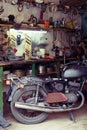 Old motorcycle, equipment and tools on the desktop in the garage