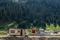 An old motorhome is standing on parking near Barskoon warefall - splashes of champagne. Travel, tourism by car concept. Summer