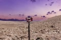 Old mountain crossroads signpost and colorful sunset sky