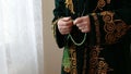 An old mullah in national dress praying with rosary beads in hands