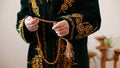 An old mullah in national dress praying with rosary beads in hands