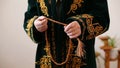 An old mullah in national dress praying with rosary beads in hands