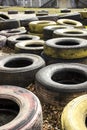 Old multi-colored tires scattered on asphalt and yellow leaves