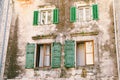 An old multi-storey building with windows and wooden shutters with peeled paint. Royalty Free Stock Photo